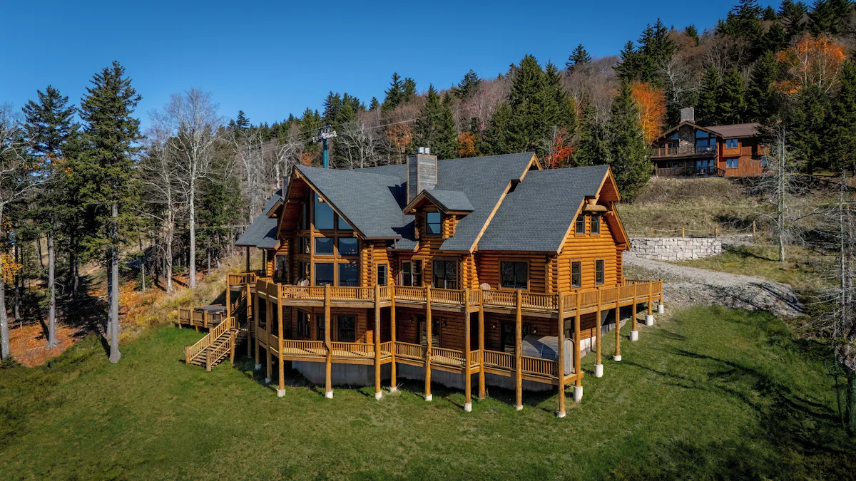 Wide elevated front exterior showing lodge and surrounding hillside